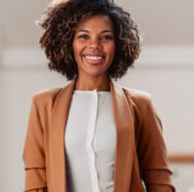 Portrait of young cheerful african american woman wearing brown suit smiling and looking at camera