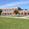 exterior of modern red brick school by a lush green lawn